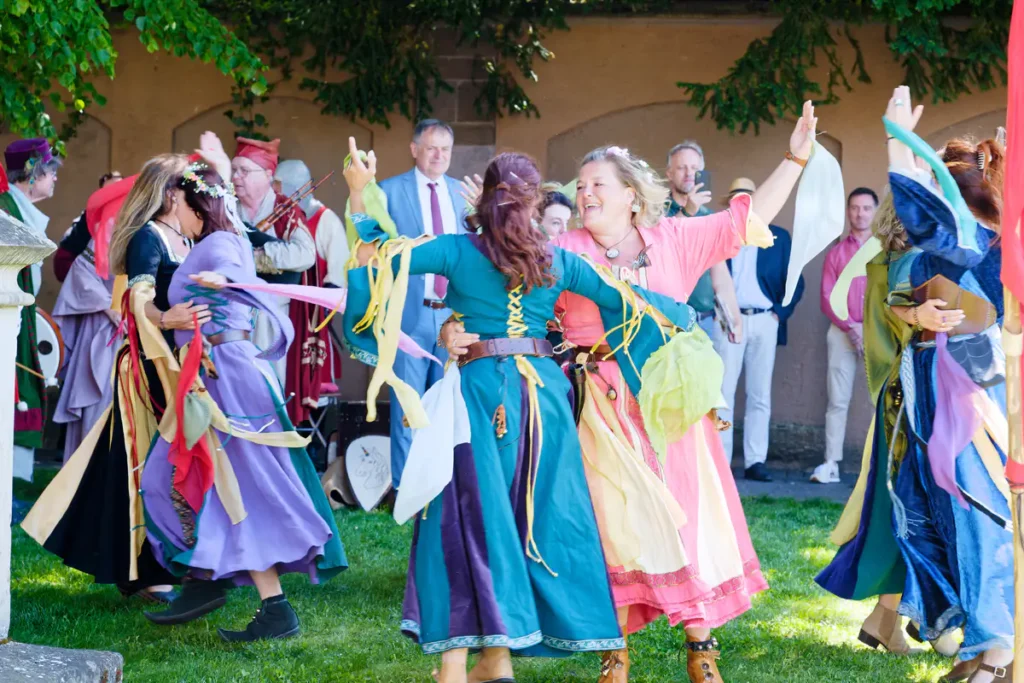 Frauen tanzen in mittelalterlichen Gewändern
