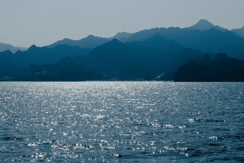 Blaues Meer, die Berge im Hintergrund sind ebenfalls bläulich
