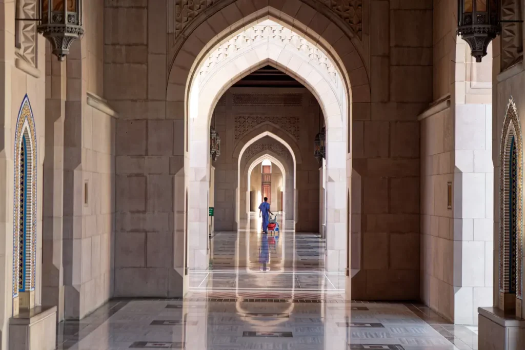 Eine Reinigungskraft auf einem perfekt glänzenden Boden der Moschee in Muskat